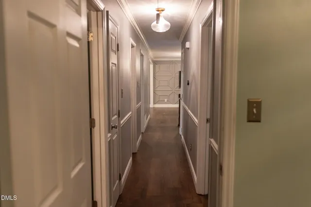 a view of a hallway with wooden floor and a mirror