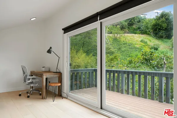 a view of a room with a large window and sitting area