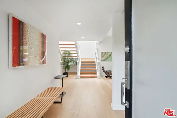 a view of a hallway with entryway and stairs