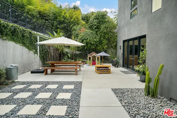 a backyard of a house with barbeque oven table and chairs