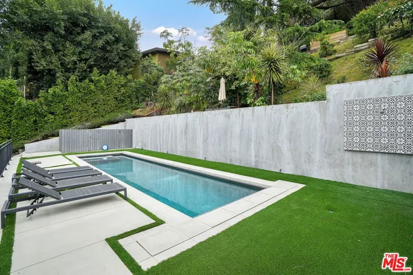 a view of a backyard with lawn chairs