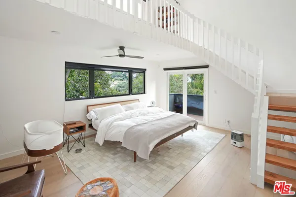 a bedroom with a bed and a large window