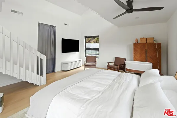 a bedroom with a bed and a flat screen tv