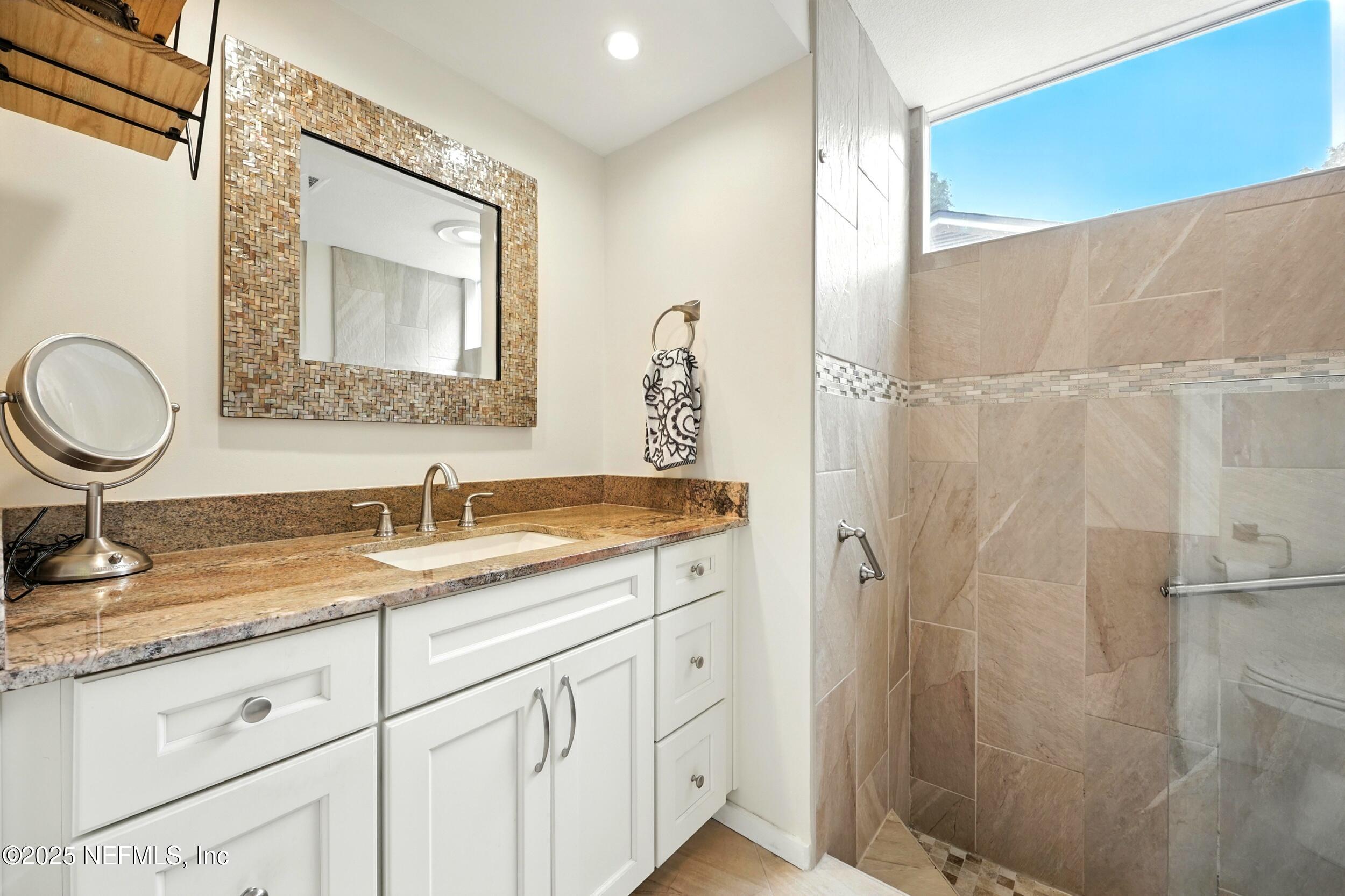 2712 Red Fox Road Orange Park, FL 32073 - Photo 19 of 30 a bathroom with a granite countertop sink a mirror and shower