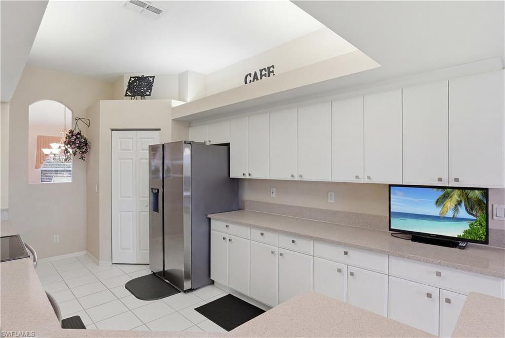 10871 Crooked River Road, Unit 202 Estero, FL 34135 - Photo 17 of 46 a kitchen with a refrigerator and cabinets
