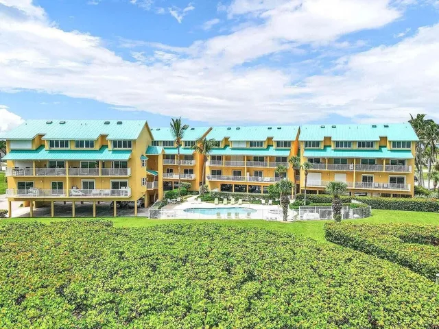 a view of building with a big yard and large trees