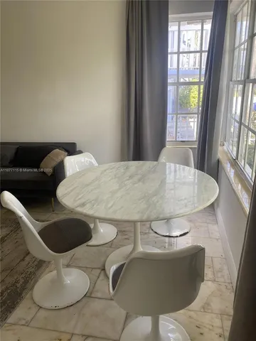 a view of a dining room with furniture wooden floor and a potted plant