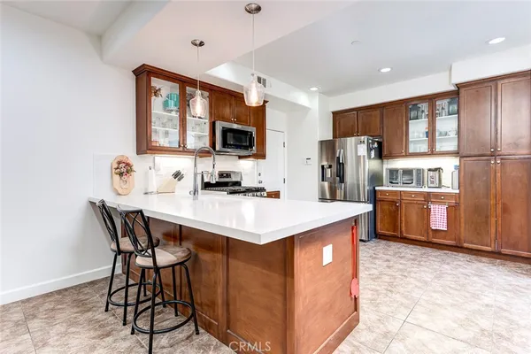 a kitchen that has a lot of cabinets a sink and a refrigerator in it
