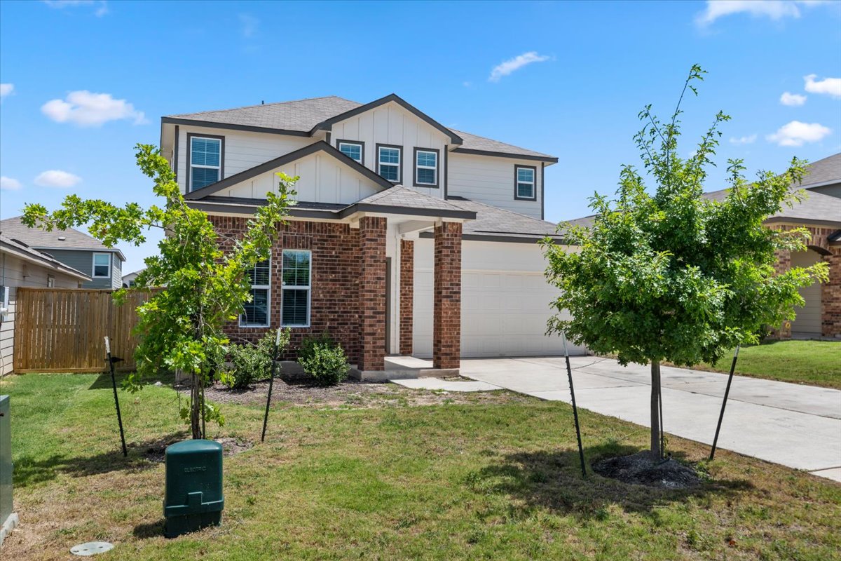 448 Perfect World Loop Jarrell, TX 76537 - Photo 2 of 40 A striking contemporary exterior with a combination of brick and siding, featuring an attached garage and a well-kept lawn.