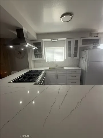 a kitchen with sink stove and cabinets
