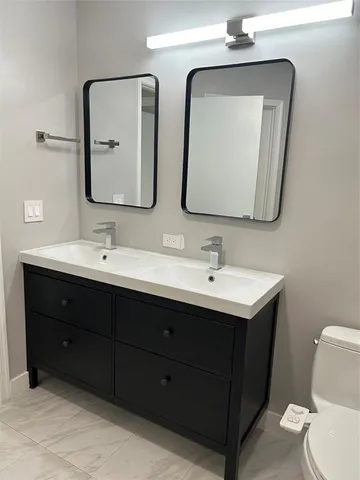a bathroom with a double vanity sink and a mirror
