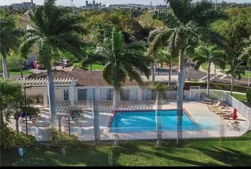 a palm tree sitting in front of a house with a garden