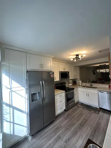 a kitchen with stainless steel appliances kitchen island granite countertop a refrigerator and a stove top oven