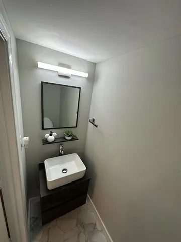 a bathroom with a sink toilet and mirror