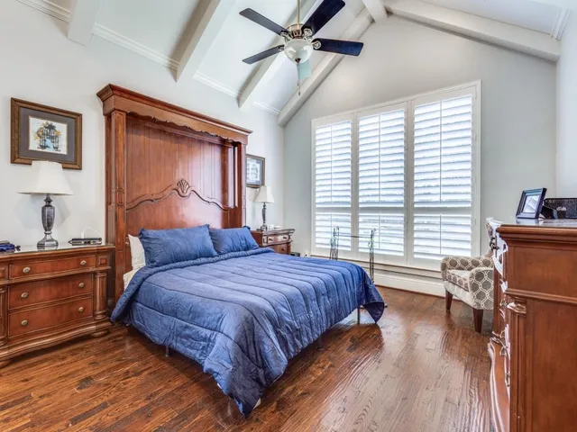 a bedroom with a bed and a dresser next to a window