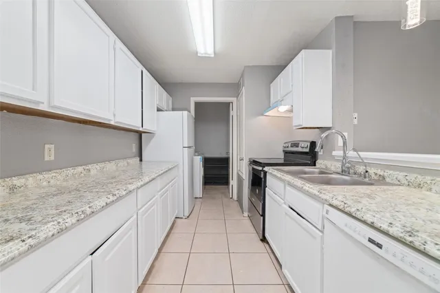 a large kitchen with granite countertop a sink and a stove
