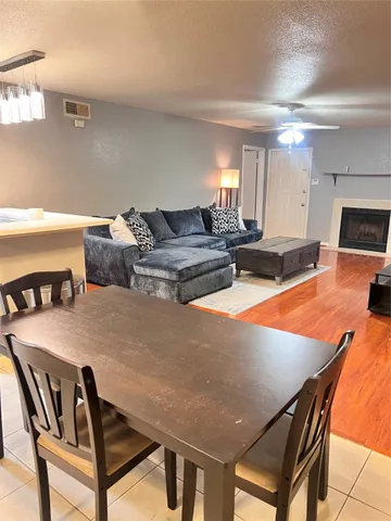 a living room with furniture a flat screen tv and kitchen view