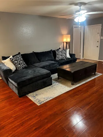 a living room with furniture and a wooden floor