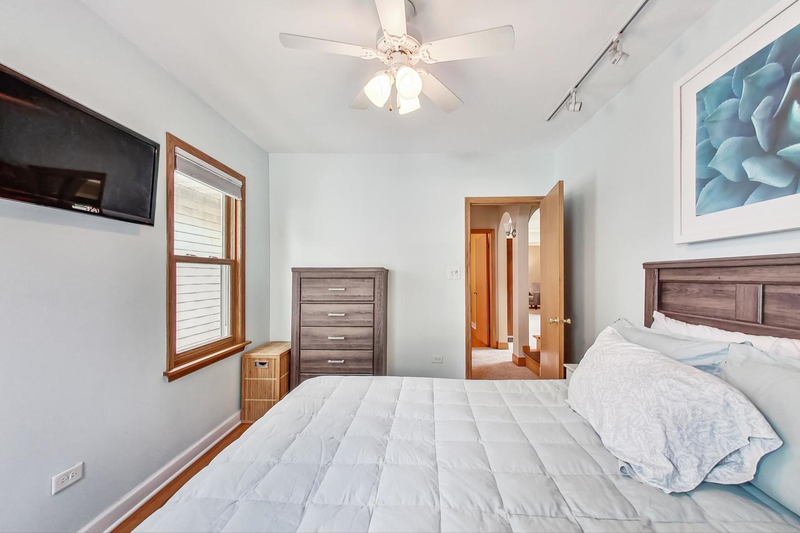 6322 West Huntington Street Chicago, IL 60646 - Photo 18 of 51 a bedroom with a bed dresser and a window