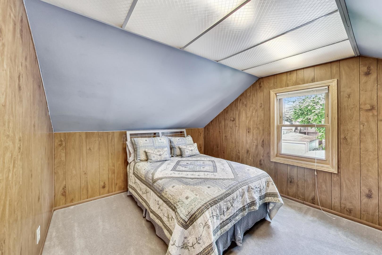 6322 West Huntington Street Chicago, IL 60646 - Photo 25 of 51 a bedroom with a bed lamp and a window