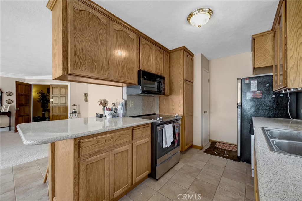 7753 Cora Drive Lucerne, CA 95458 - Photo 15 of 36 a kitchen with stainless steel appliances granite countertop a refrigerator a stove and a sink