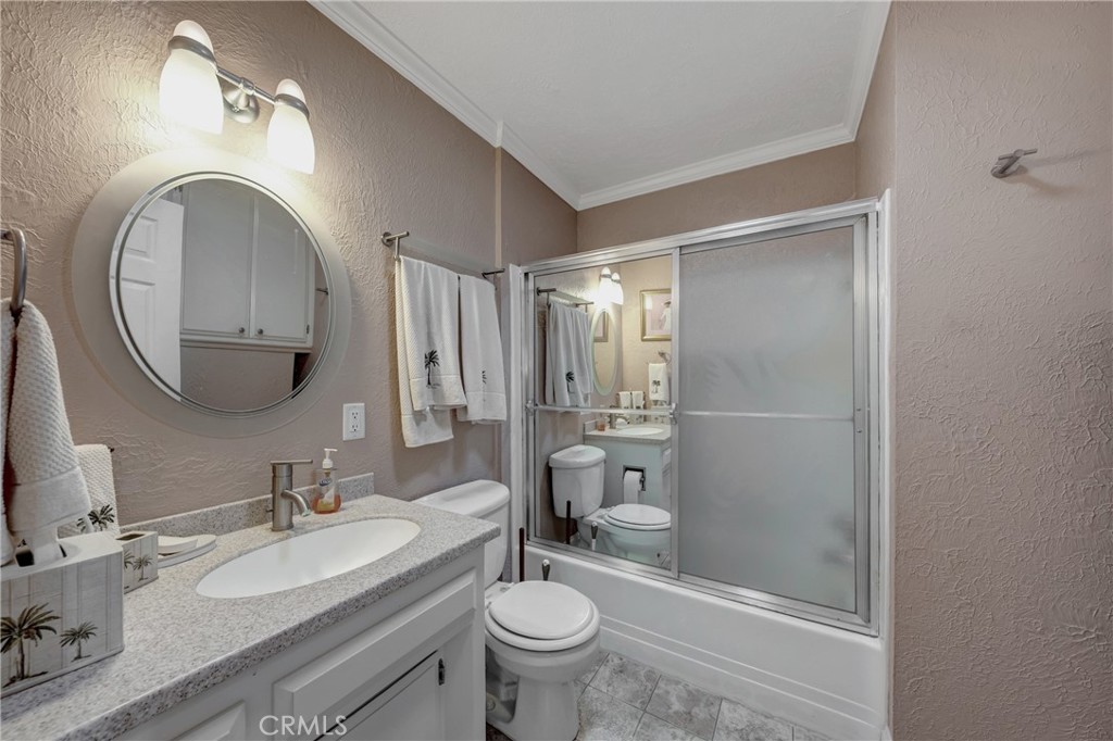 7753 Cora Drive Lucerne, CA 95458 - Photo 19 of 36 a bathroom with a granite countertop toilet a sink and a mirror