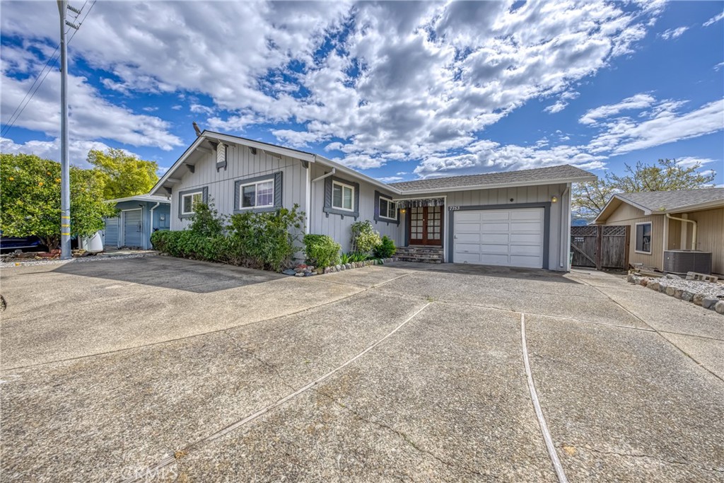 7753 Cora Drive Lucerne, CA 95458 - Photo 4 of 36 a front view of a house with a yard and garage