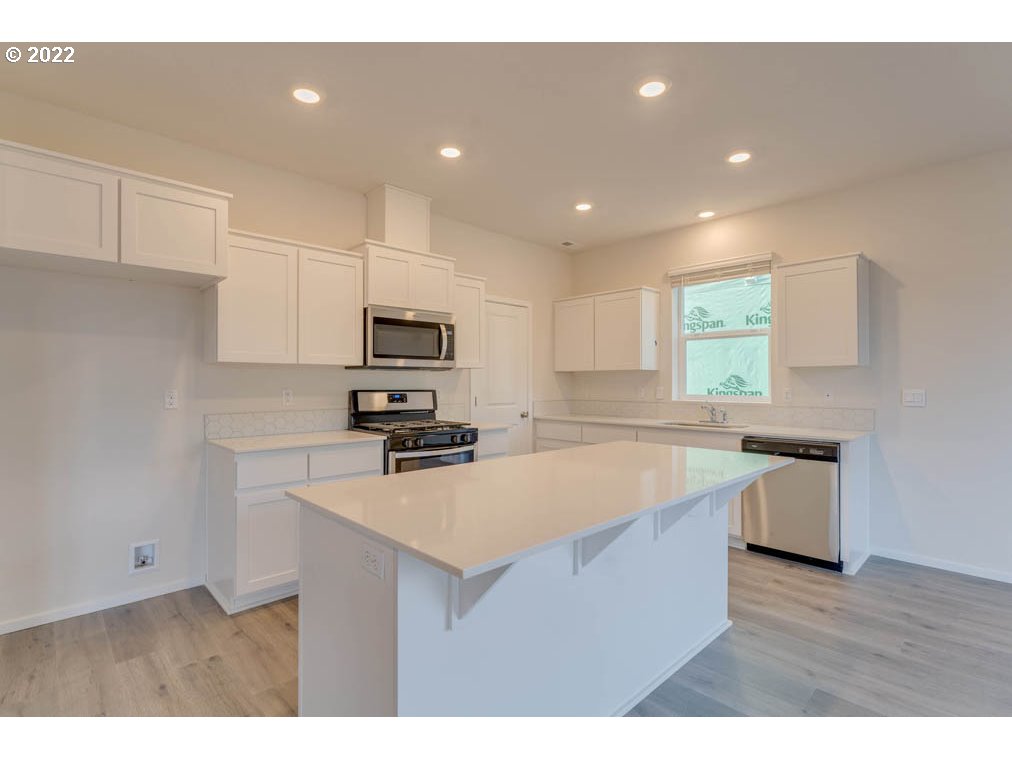 2894 V Street Springfield, OR 97477 - Photo 7 of 23 a kitchen with stainless steel appliances granite countertop a sink dishwasher a stove and a refrigerator with wooden floor