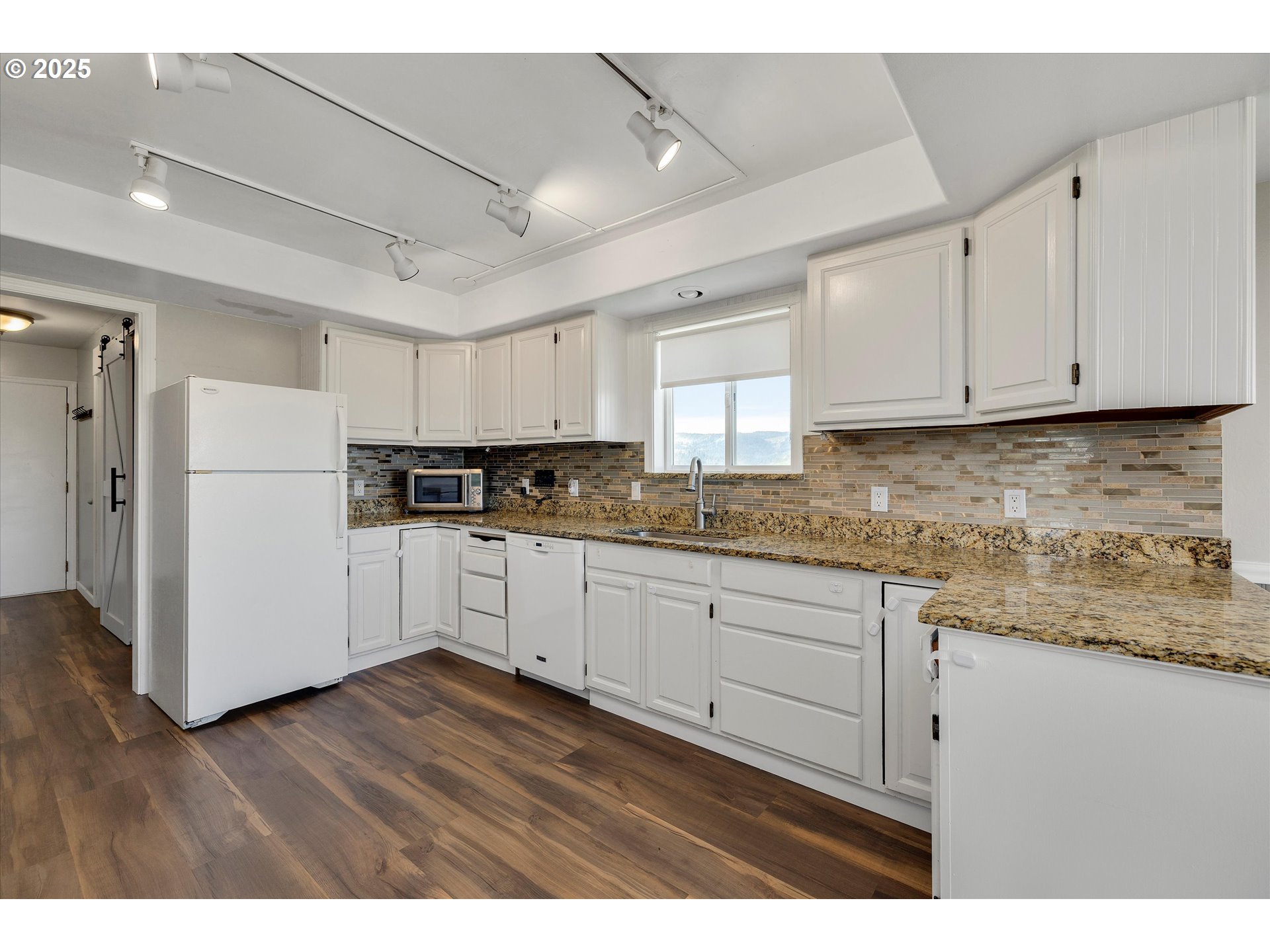 1805 Carroll Road Mosier, OR 97040 - Photo 19 of 45 a kitchen with cabinets appliances wooden floor and a window