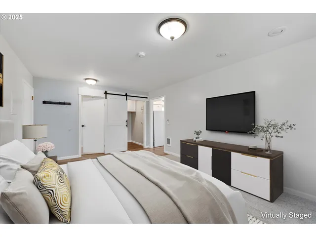 a bedroom with a bed and a flat screen tv