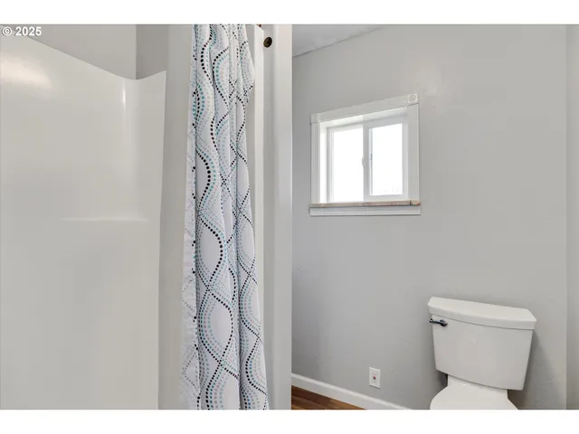 a bathroom with a toilet and a shower curtain
