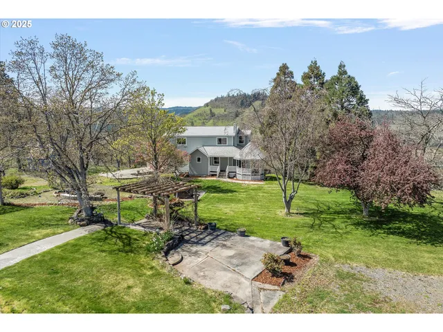 a view of backyard of house with outdoor seating and green space