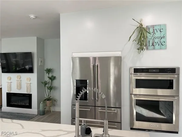 a kitchen with stainless steel appliances a stove a microwave and a potted plant