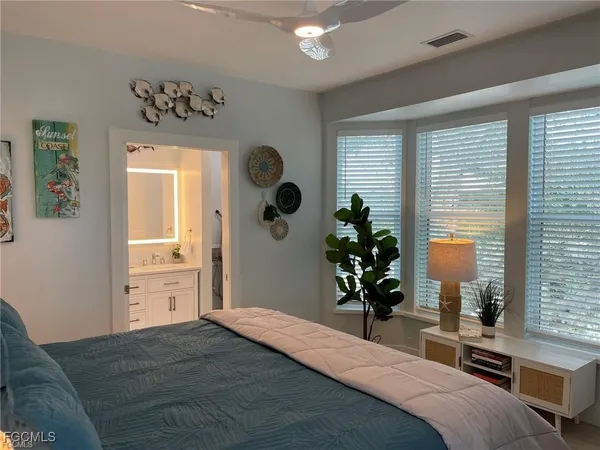a bedroom with a bed and a potted plant