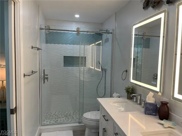 a bathroom with a granite countertop sink toilet and shower