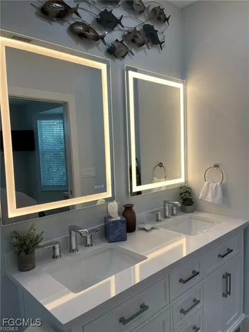 a bathroom with a sink and two mirror