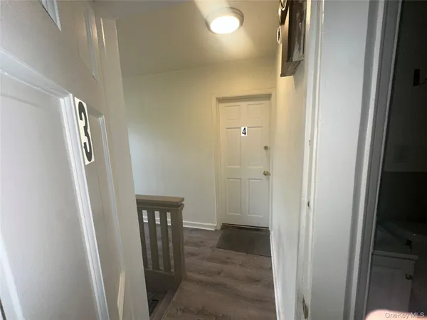 a view of a hallway with wooden floor and glass door