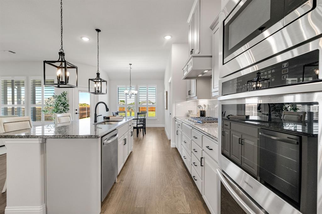 707 Soprano Drive Forney, TX 75126 - Photo 15 of 37 a kitchen with stainless steel appliances granite countertop lots of counter top space and wooden floor
