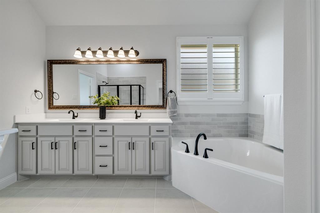 707 Soprano Drive Forney, TX 75126 - Photo 21 of 37 a bathroom with a sink double vanity mirror and bathtub