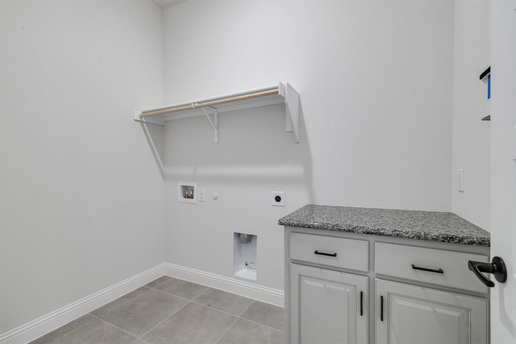 707 Soprano Drive Forney, TX 75126 - Photo 30 of 37 a hallway with granite countertop white cabinets and a granite counter tops