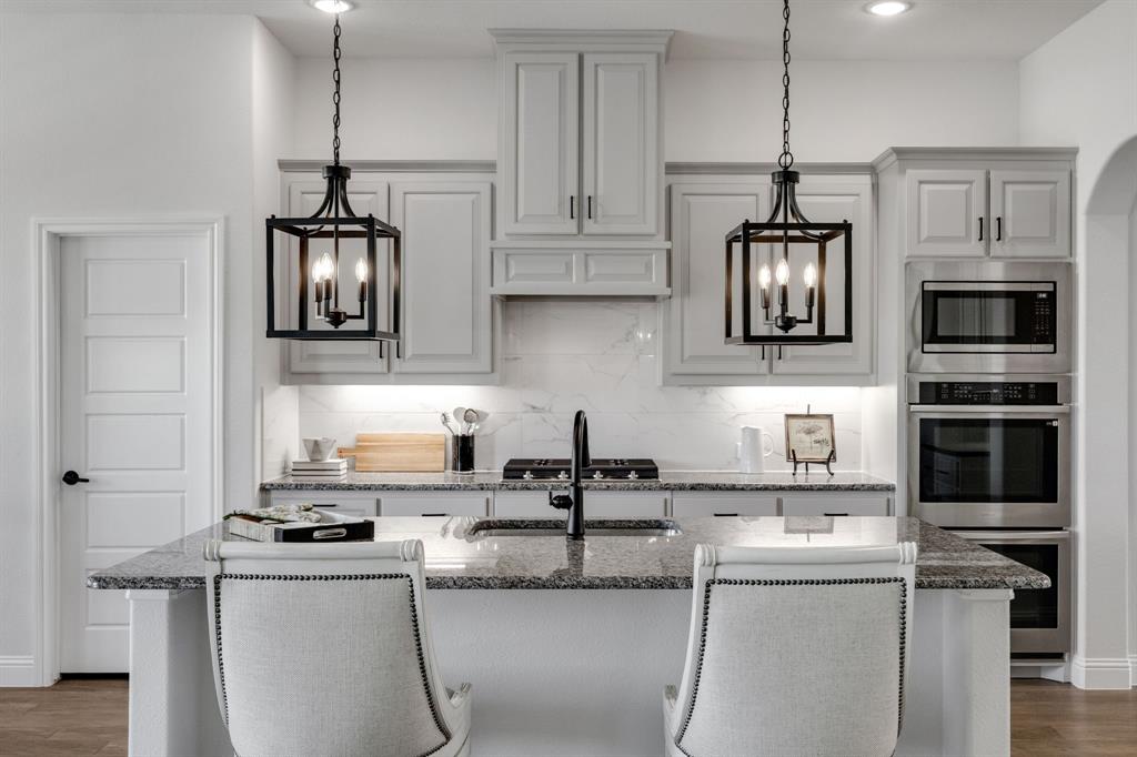 707 Soprano Drive Forney, TX 75126 - Photo 5 of 37 a kitchen with stainless steel appliances granite countertop a sink and a stove