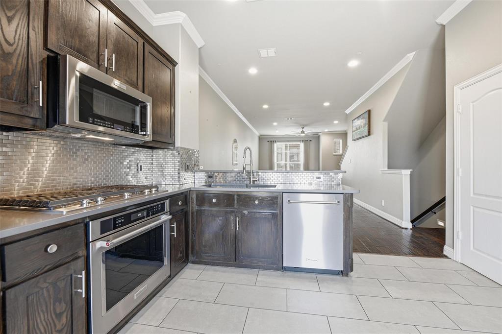 722 East 1st Street Fort Worth, TX 76102 - Photo 5 of 30 The kitchen is spacious and impresses with mahogany cabinetry and striking backsplash.
