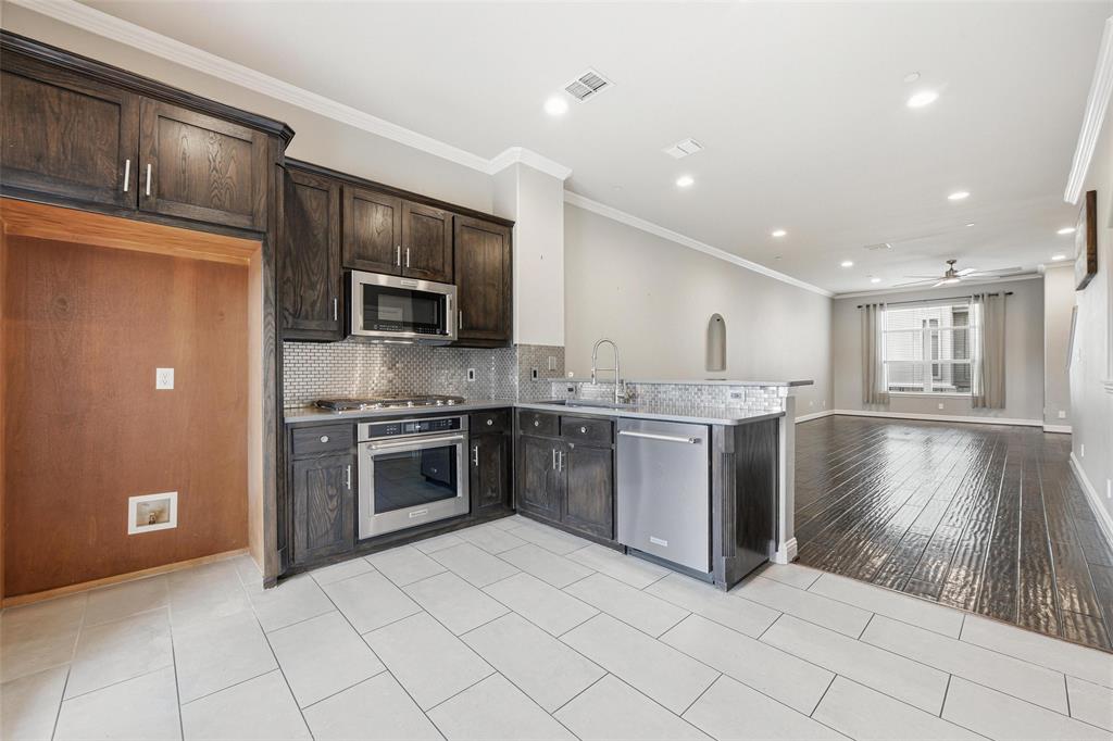 722 East 1st Street Fort Worth, TX 76102 - Photo 6 of 30 The kitchen shines with a breakfast bar, quartz countertops, and stainless steel appliances.