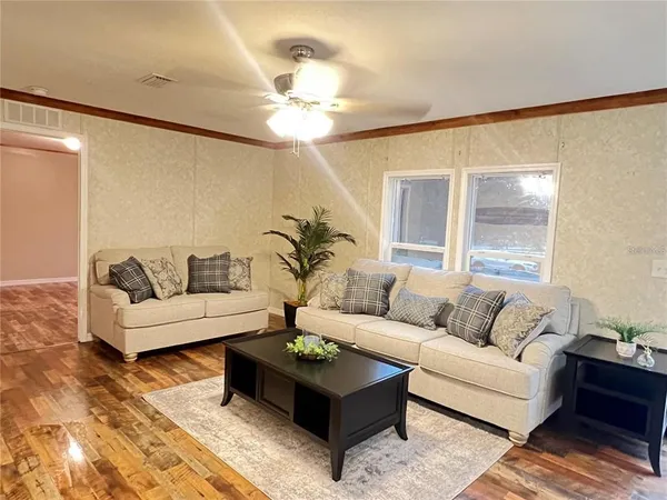 a living room with furniture and a wooden floor