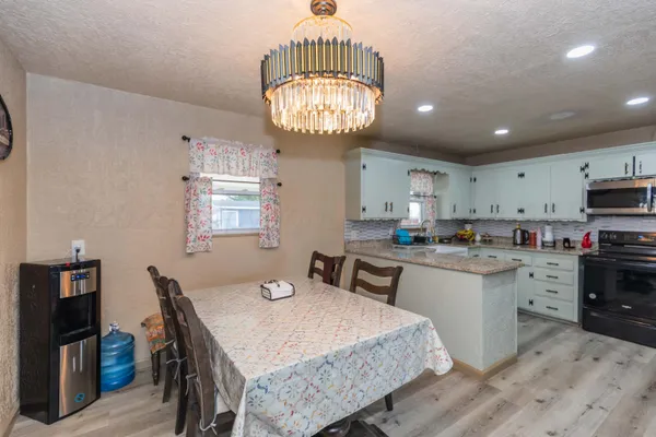 a large kitchen with kitchen island a dining table and chairs