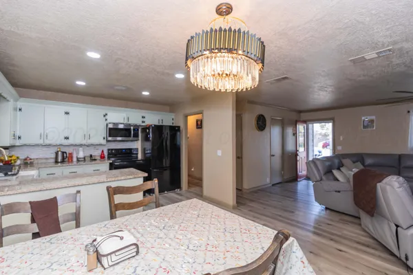 a kitchen with a refrigerator and a wooden floor