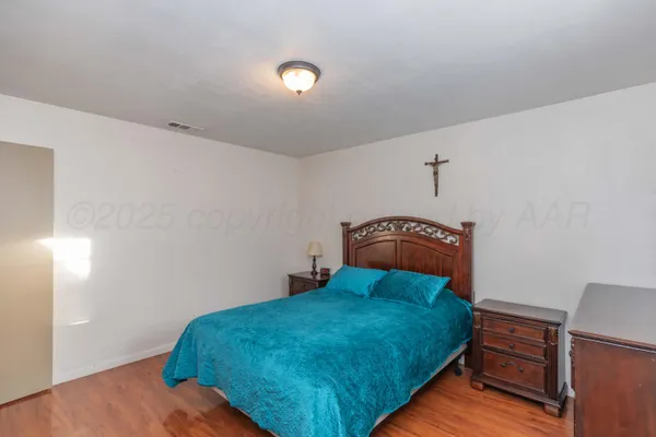 a bedroom with a bed and wooden floor