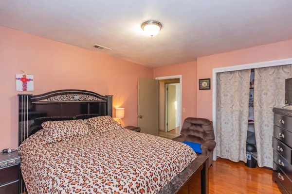 a bedroom with a bed and a lamp with the dresser