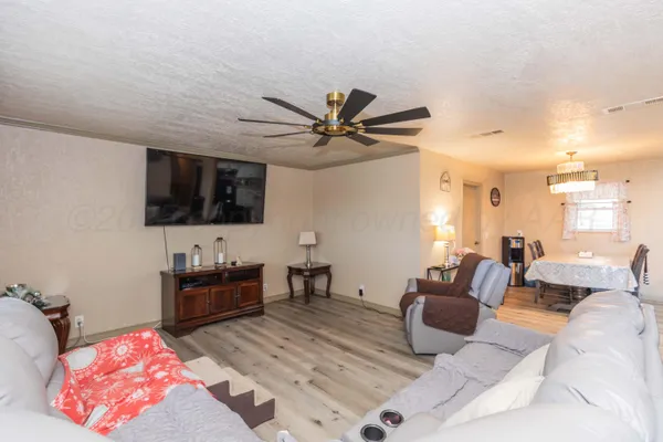 a living room with furniture kitchen view and a flat screen tv