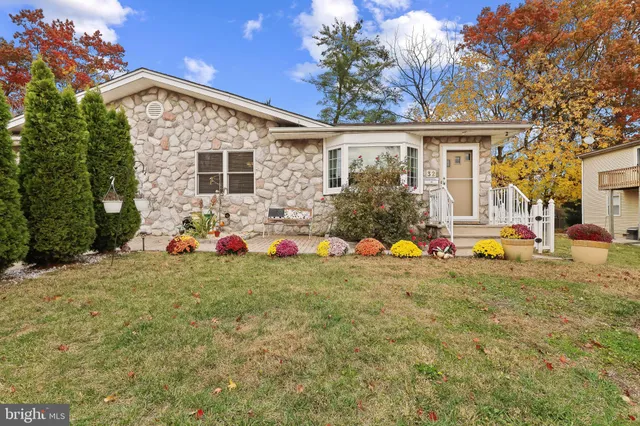 a backyard of a house with table and chairs and potted plants